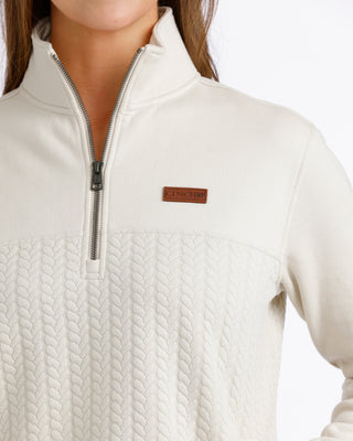 Close-up of Cinch Women’s cream pullover quarter zip and logo