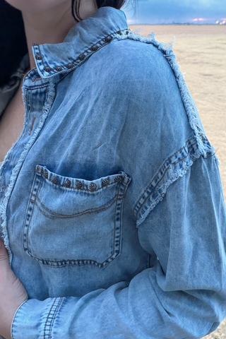 Close-up of Sterling Kreek studded denim shacket chest pocket and shoulder trim