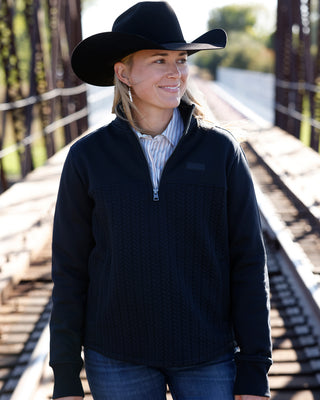 Cinch Women’s black 1/4 zip pullover styled with Western shirt and jeans