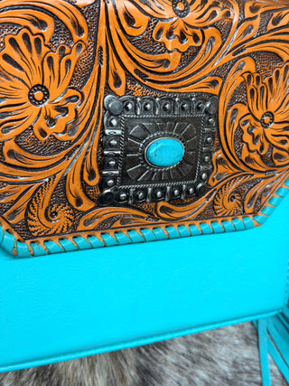 Western tooled leather crossbody handbag with turquoise accents, square conchos, and metal feet