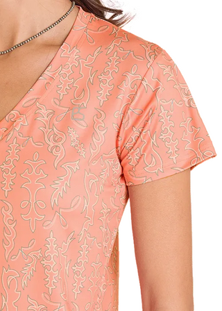 Close-up of Panhandle Slim peach-orange Western tee showing intricate cream and tan cowboy boot stitch-inspired floral scroll print.