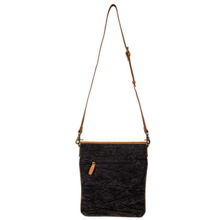 Black and white hide crossbody bag with a brown strap on a white background